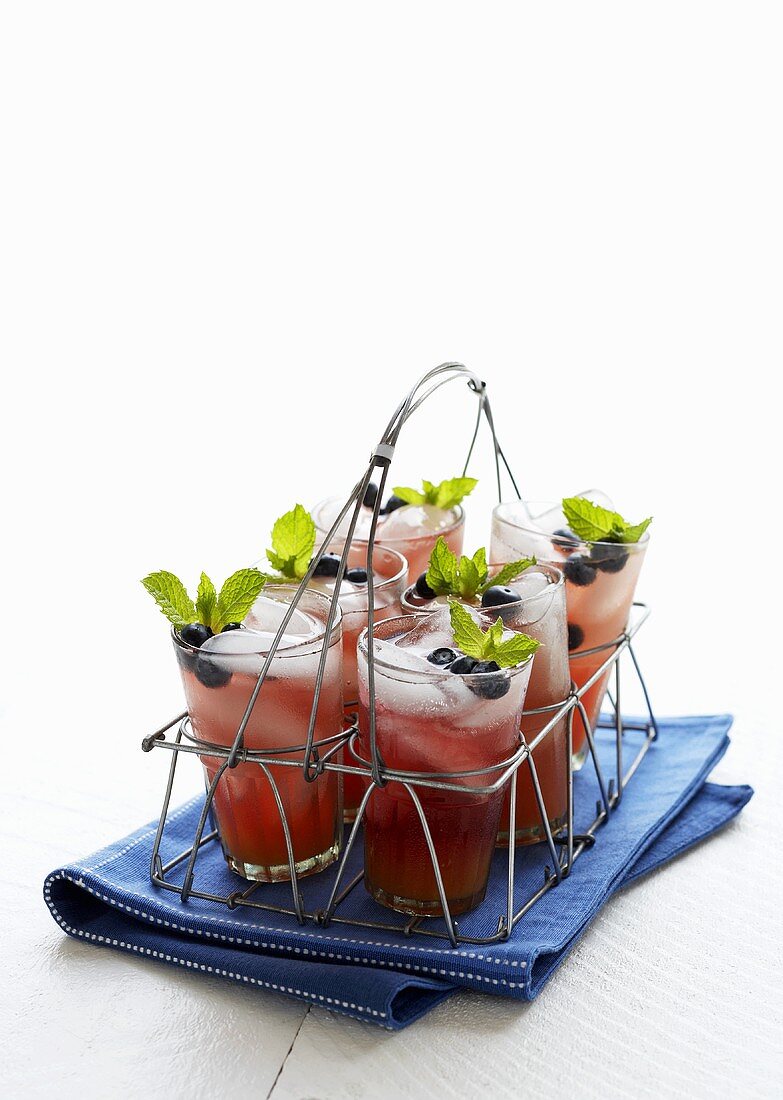 Glasses of Blueberry Lemonade in a Wire Drink Carrier; On a Blue Dish Cloth