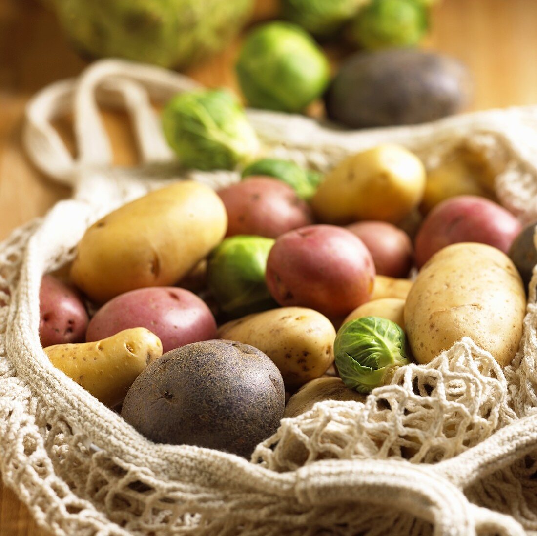Verschiedene Kartoffelsorten und Rosenkohlröschen im Netz