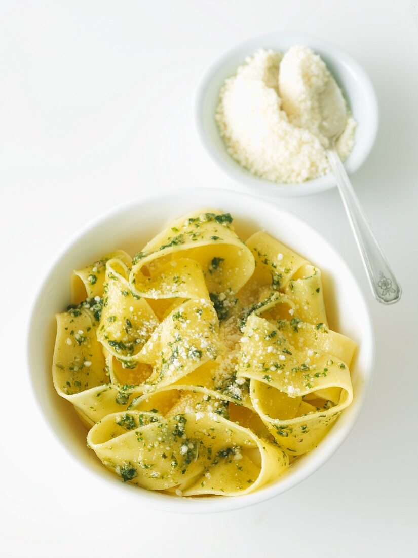 Bowl of Fresh Pasta with Pesto and Parmesan Cheese; Parmesan Cheese in a Bowl