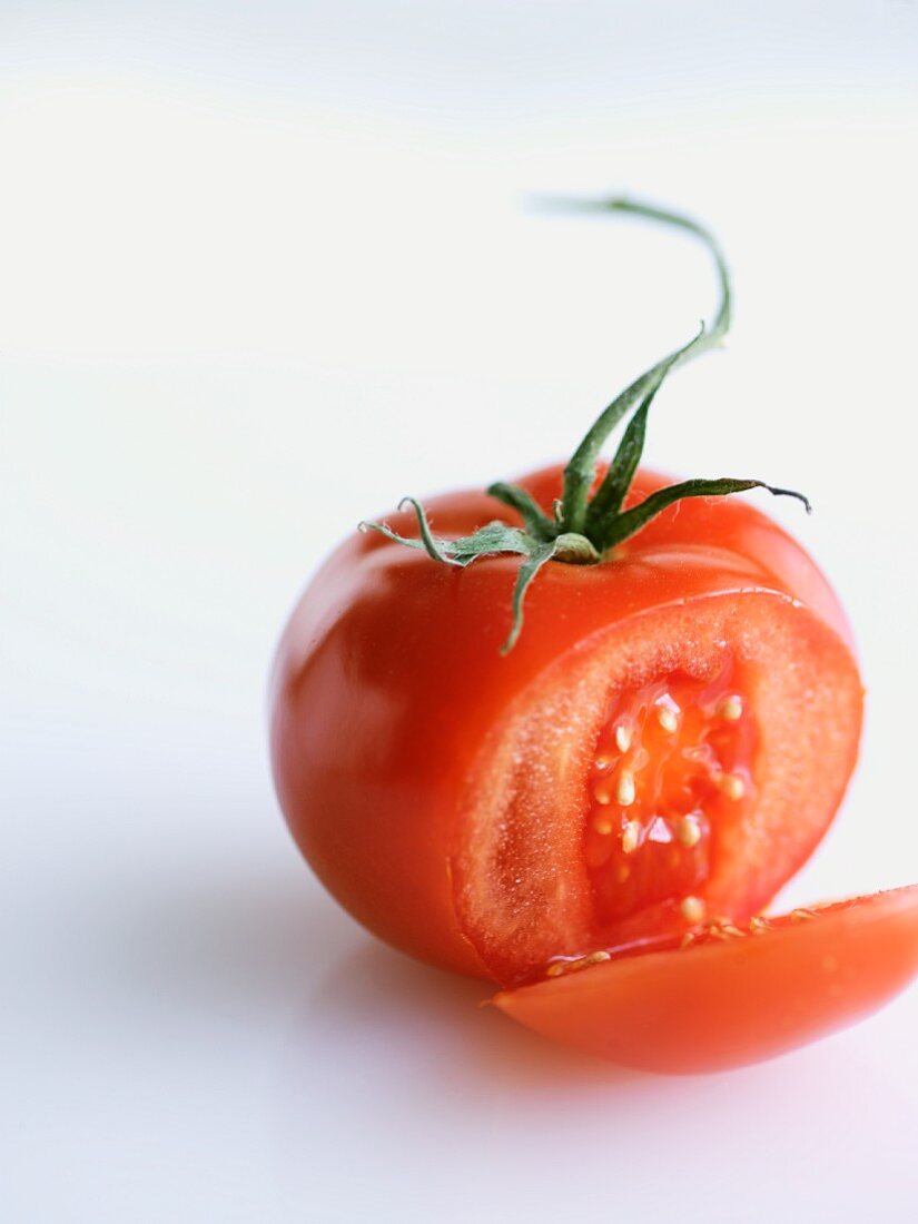 Vine Ripe Tomato Sliced Once; White Background