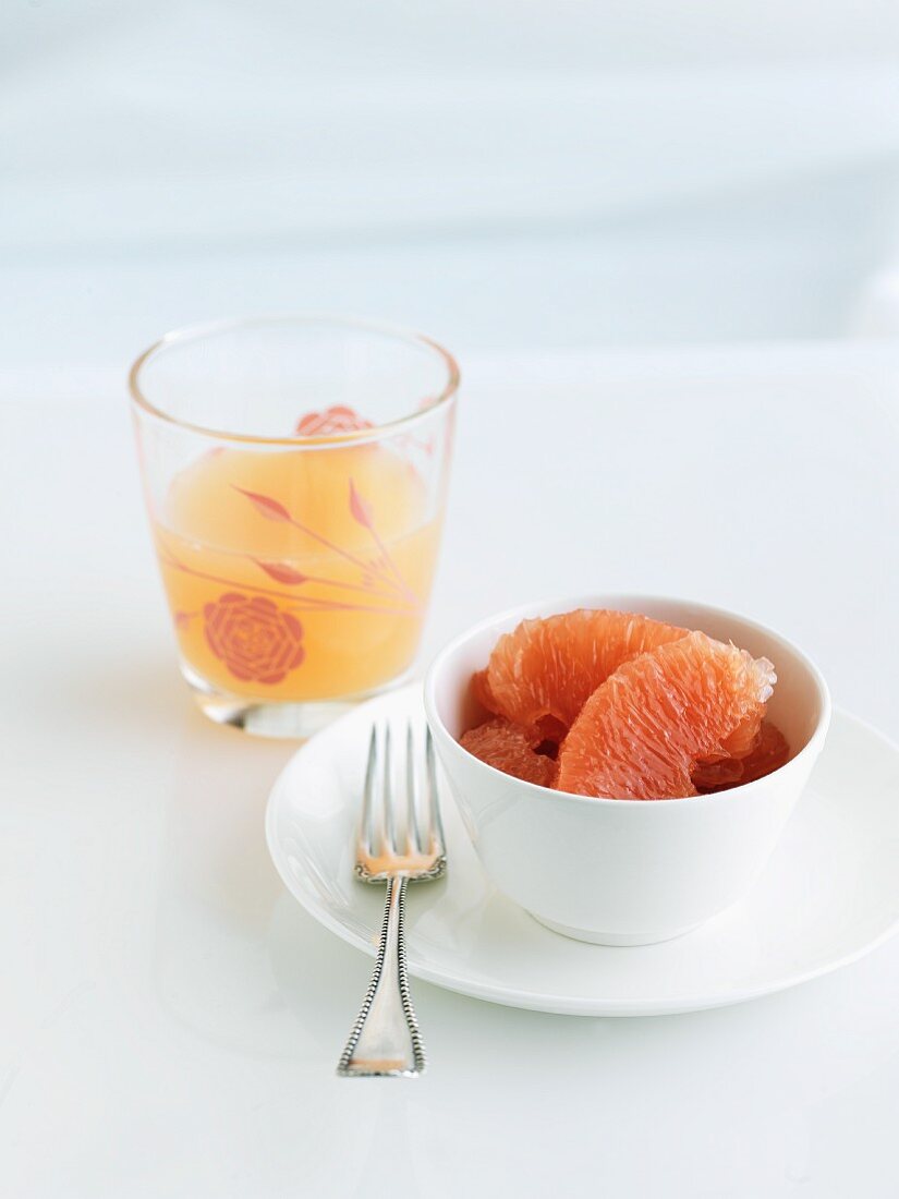 Pink Grapefruit Segments in a Bowl; Glass of Grapefruit Juice