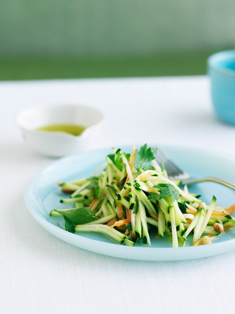 Raw Food Salad with Zucchini on a Blue Plate; Fork