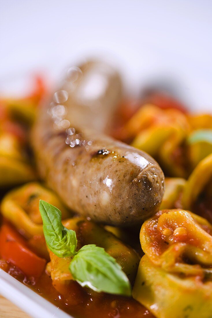 Ganze Bratwurst auf Tortellini (Nahaufnahme)