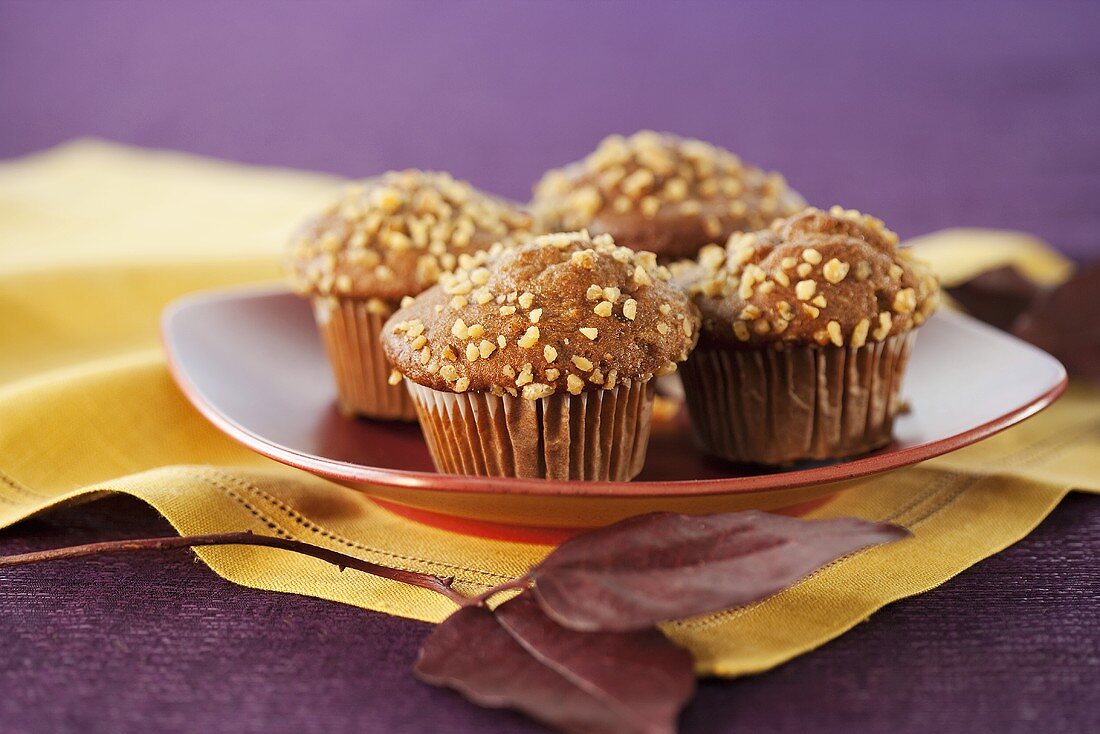 Vier Apfel-Nuss-Muffins auf Teller