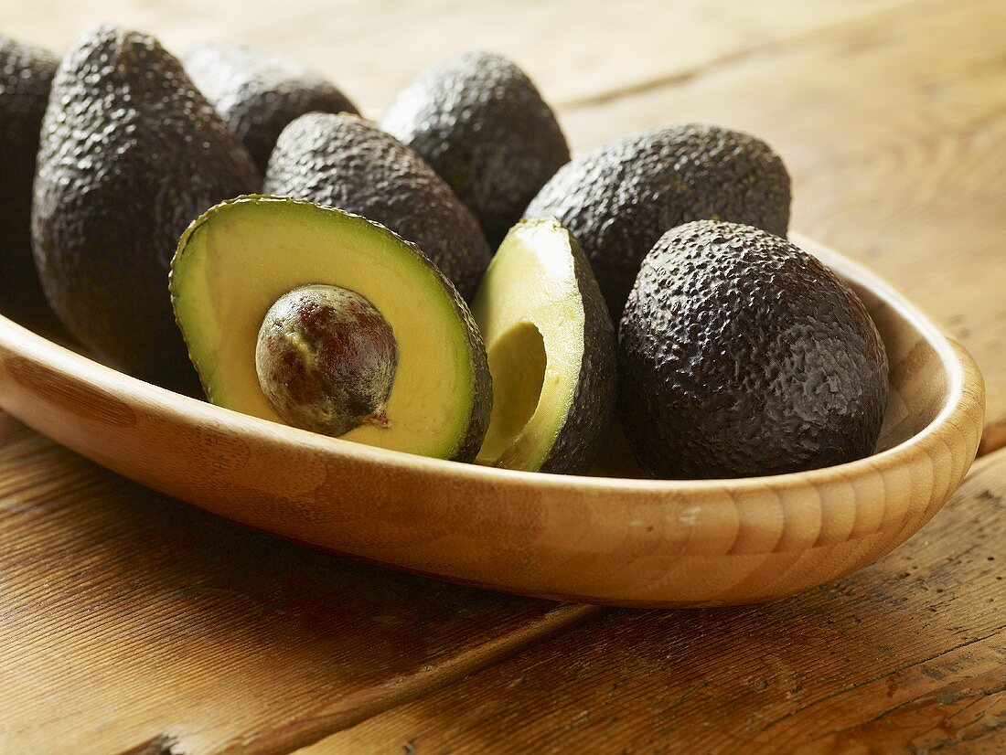 Wooden Dish of Avocados; One Halved