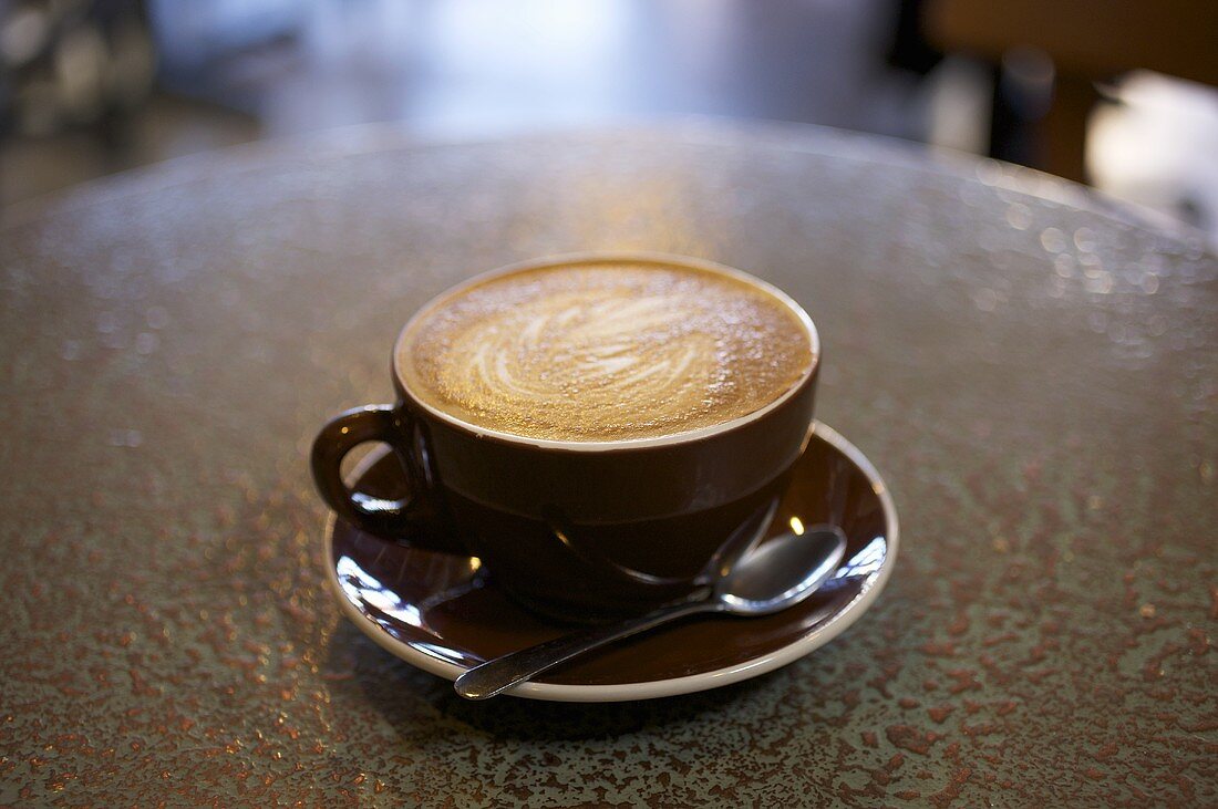 Caffe latte auf Tisch im Kaffeehaus