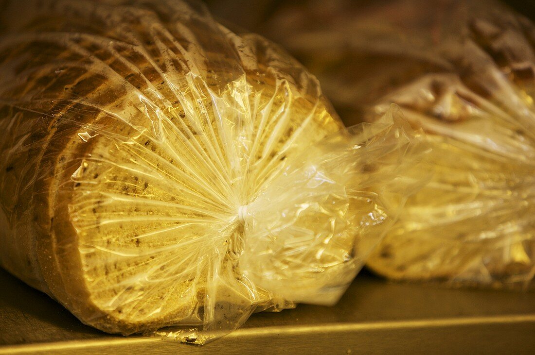 Sliced Loaves of Rye Bread Wrapped in Plastic on Shelf