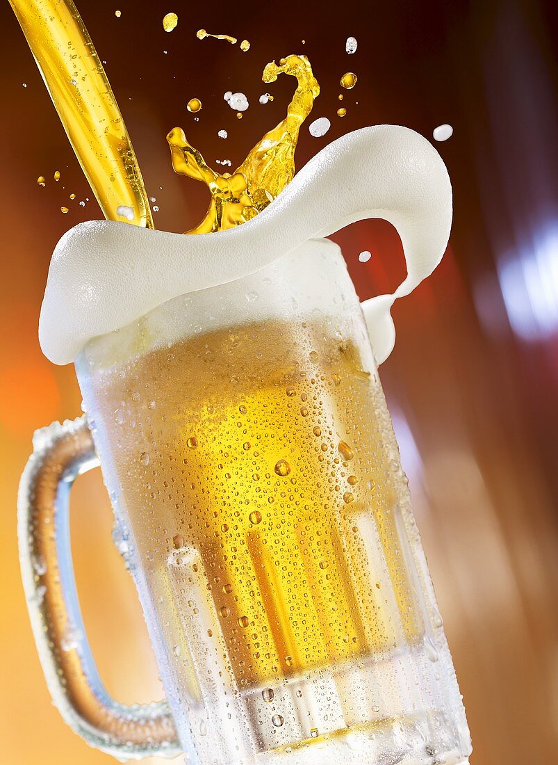 Beer being poured into a glass tankard