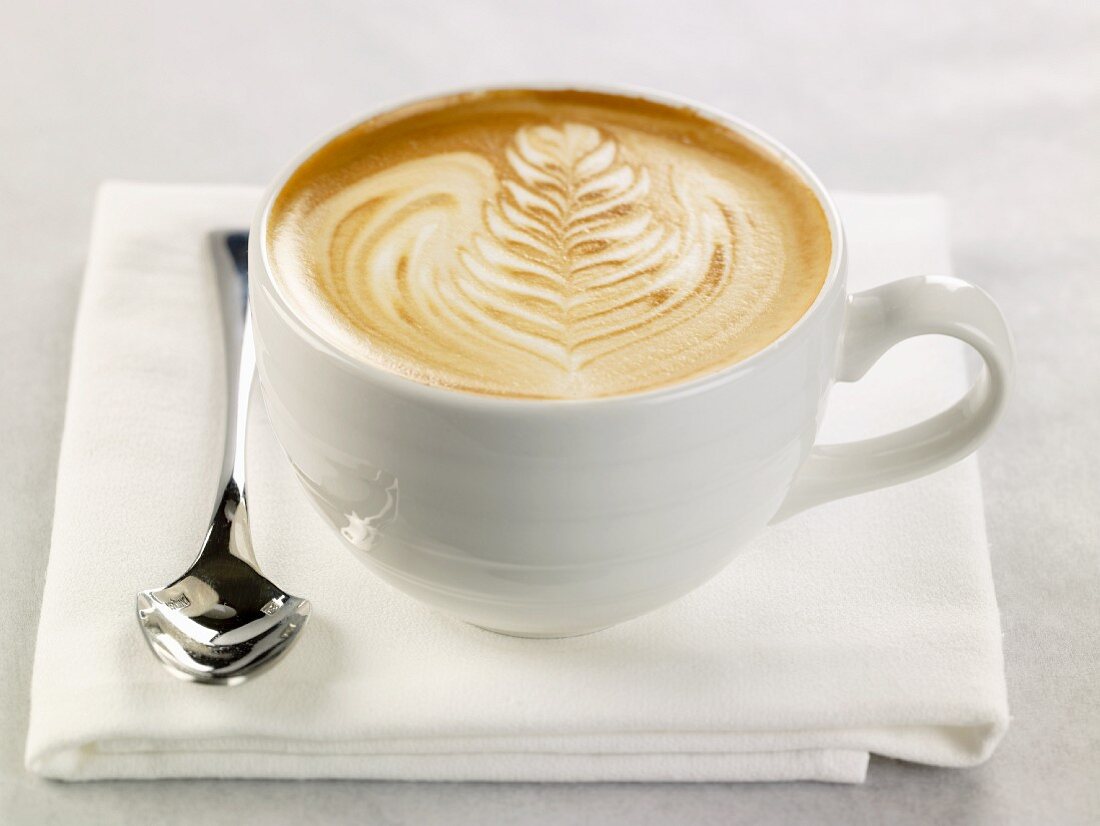 Latte in a White Mug; Spoon; On White Napkin