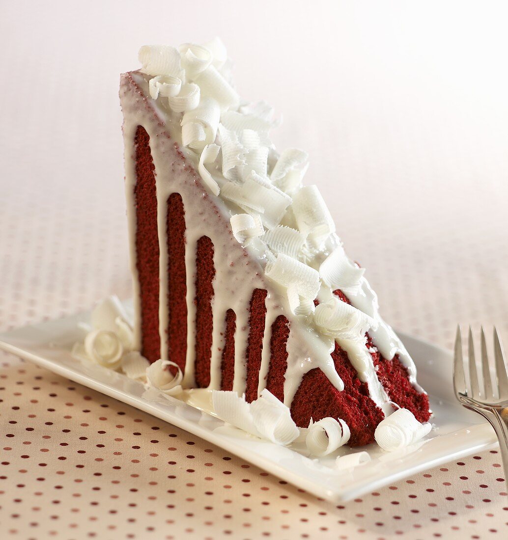 Ein Stück Red Velvet Cake mit weissen Schokoröllchen (USA)