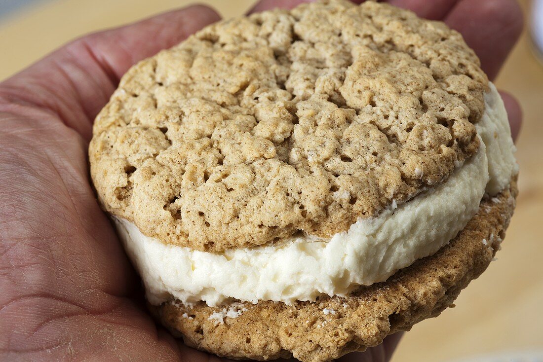 A hand holding an oatmeal whoopie pie from Lancaster County, PA