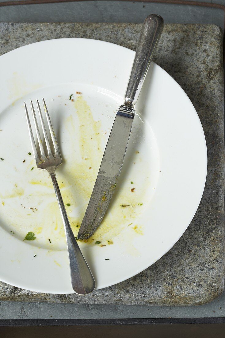 Empty Plate with Egg Remains; Fork and Knife
