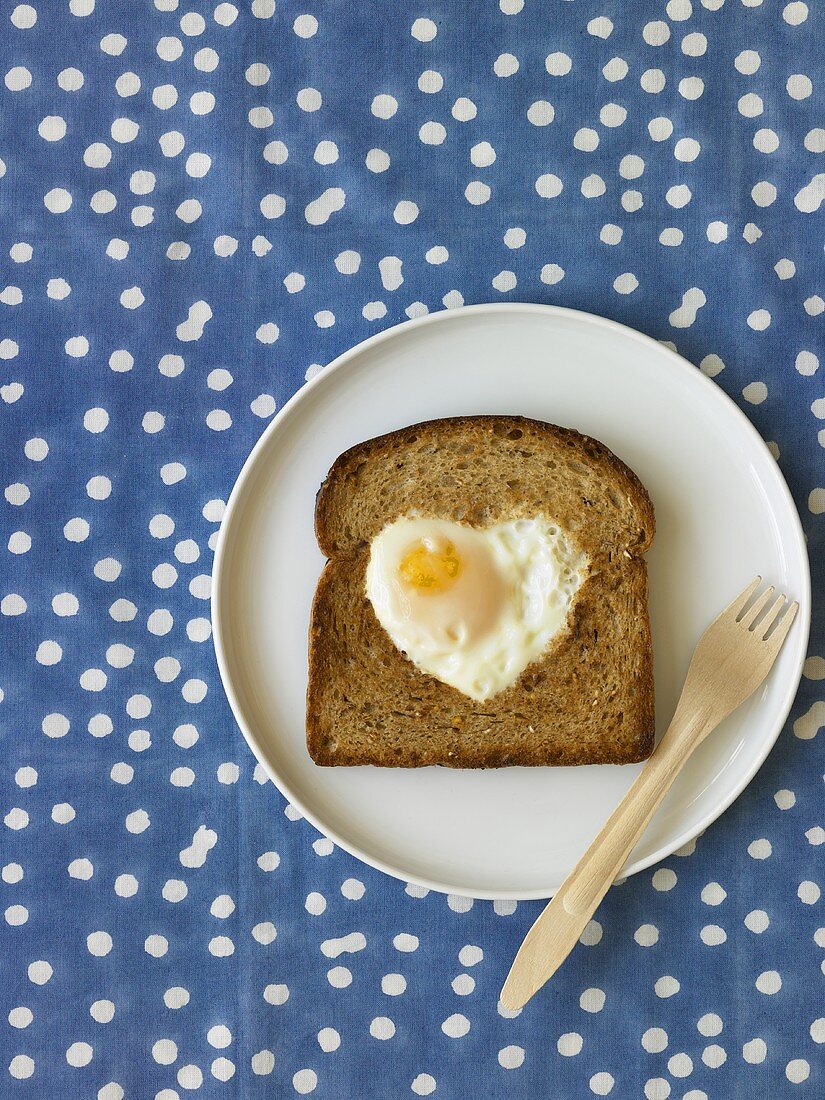 Heart Shaped Fried Egg on Slice of Whole Grain Toast; Fork