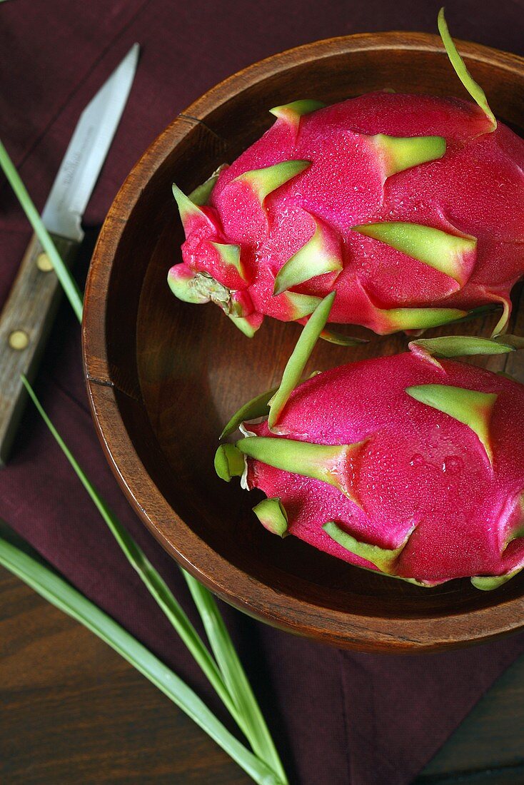 Two Whole Dragon Fruit in a Wooden Bowl