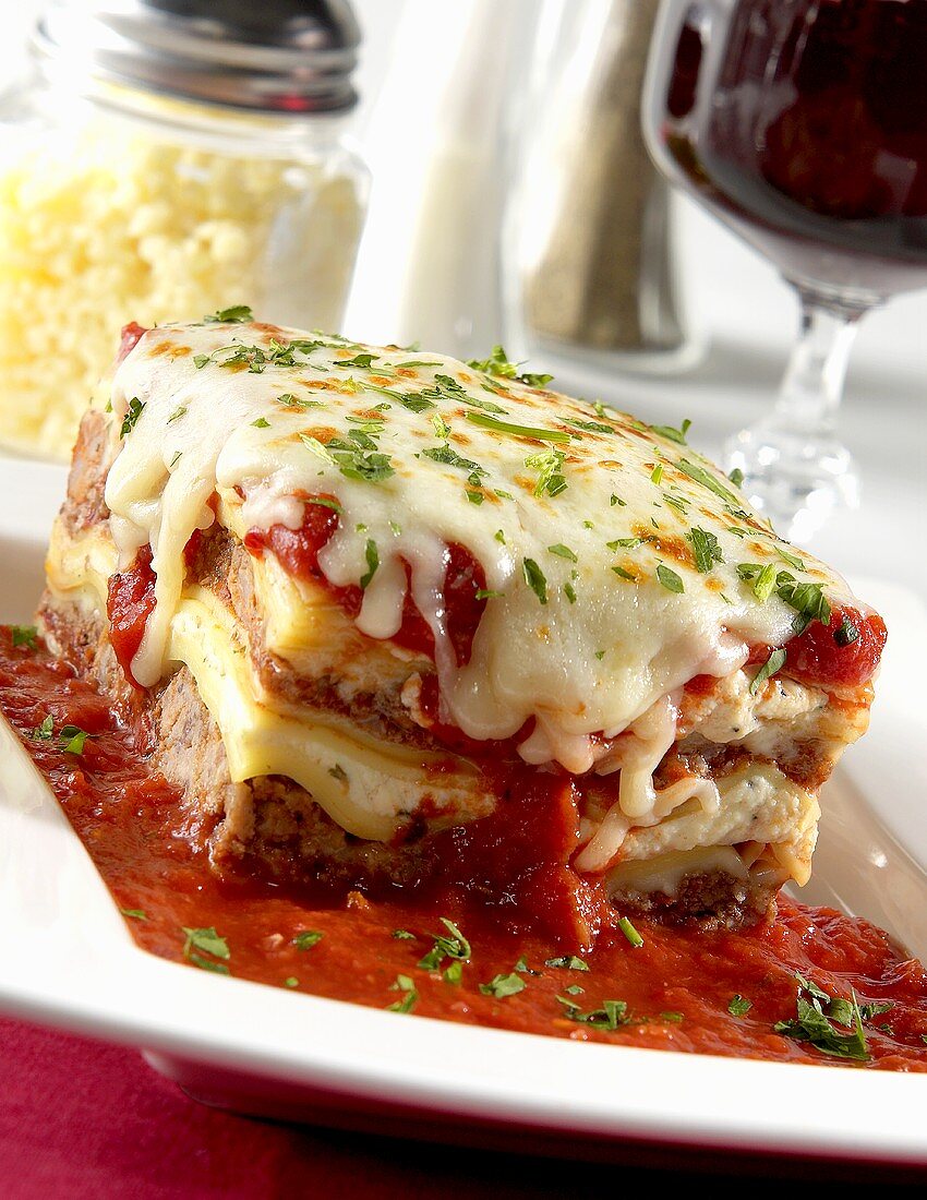 Piece of Lasagna with Tomato Sauce on a White Plate
