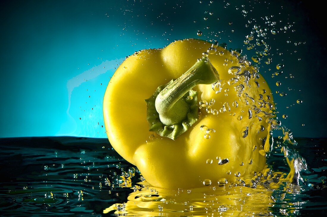 Gelbe Paprikaschote fällt ins Wasser