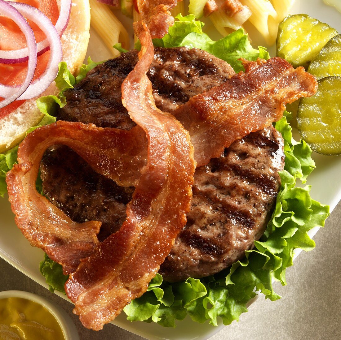Grilled Bacon Burger with Lettuce; Top Bun Off; Pickles