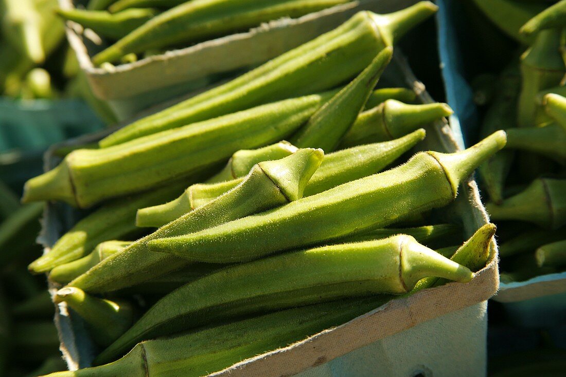 Frische Okraschoten in Pappschälchen auf dem Markt