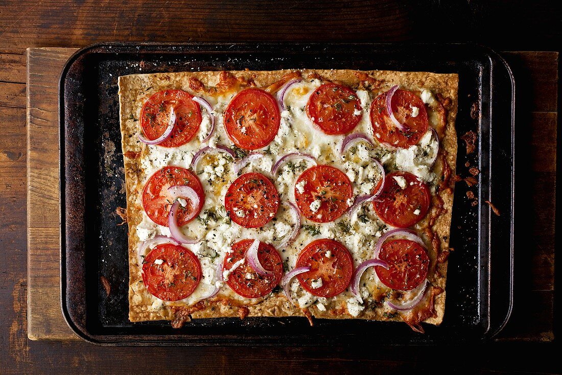Rectangular Tomato and Onion Pizza on Baking Sheet
