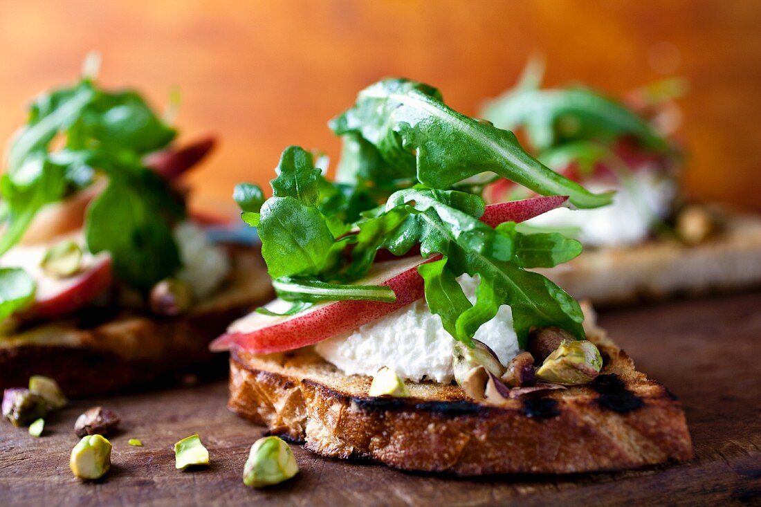 Crostini mit Käse, Birnen, Nüssen und Rucola