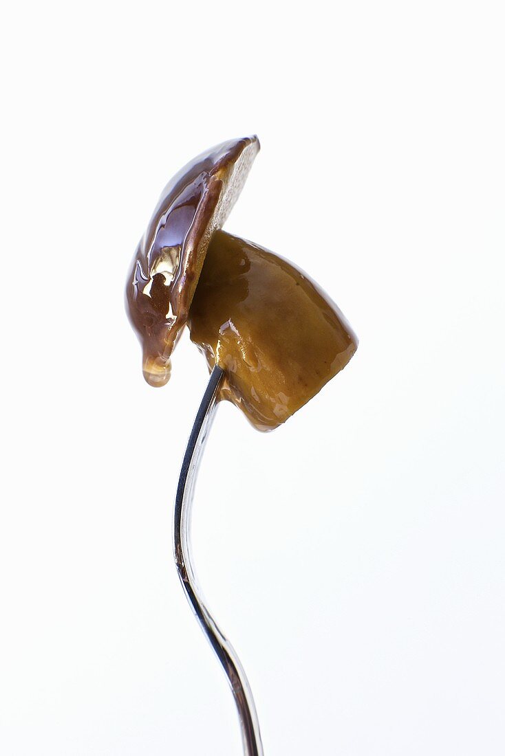 Marinated Wild Mushroom on a Fork; White Background