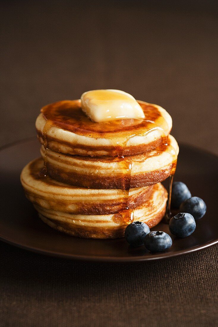 Pancakes mit Butter, Ahornsirup und Heidelbeeren