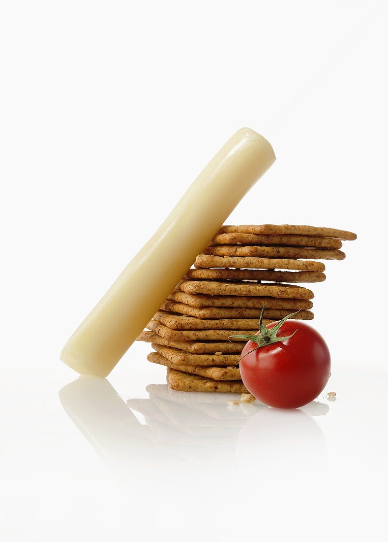 Cheese Stick with a Stack of Crackers and a Tomato