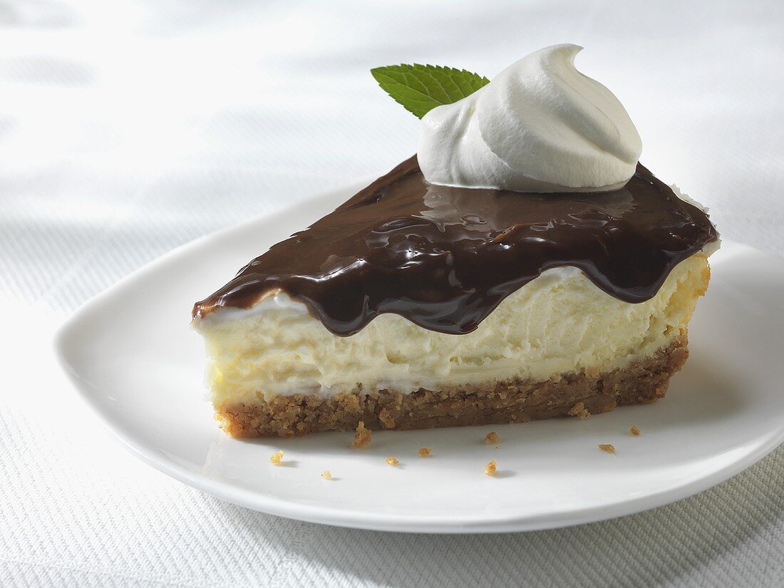 Slice of Cheesecake with Chocolate Sauce Topping and Whipped Cream