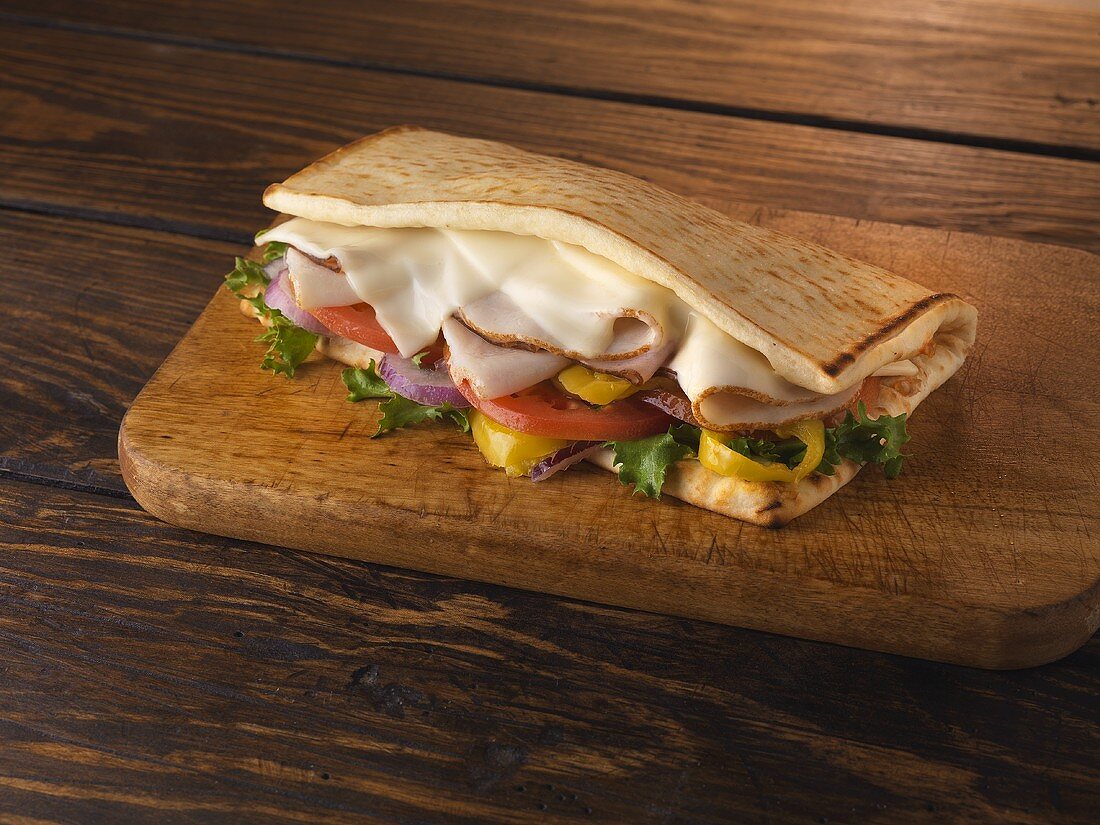Flatbread Sandwich with Turkey, Swiss Cheese, Lettuce, Tomato, Onion and Banana Peppers
