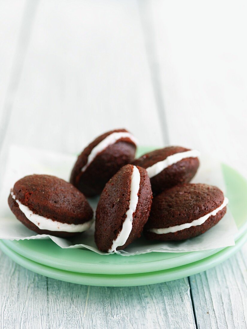 Mini Red Velvet Whoopie Pies on Stacked Green Plates