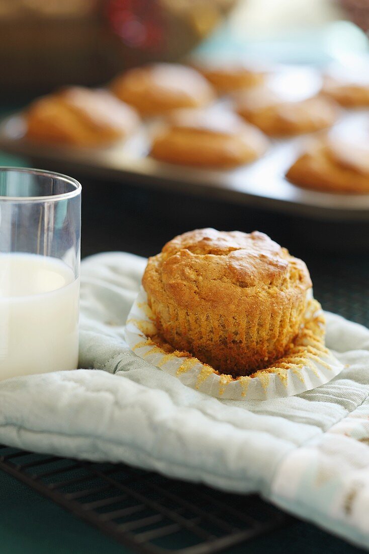 Freshly Baked Muffin with a Glass of Milk on an Oven Mitt