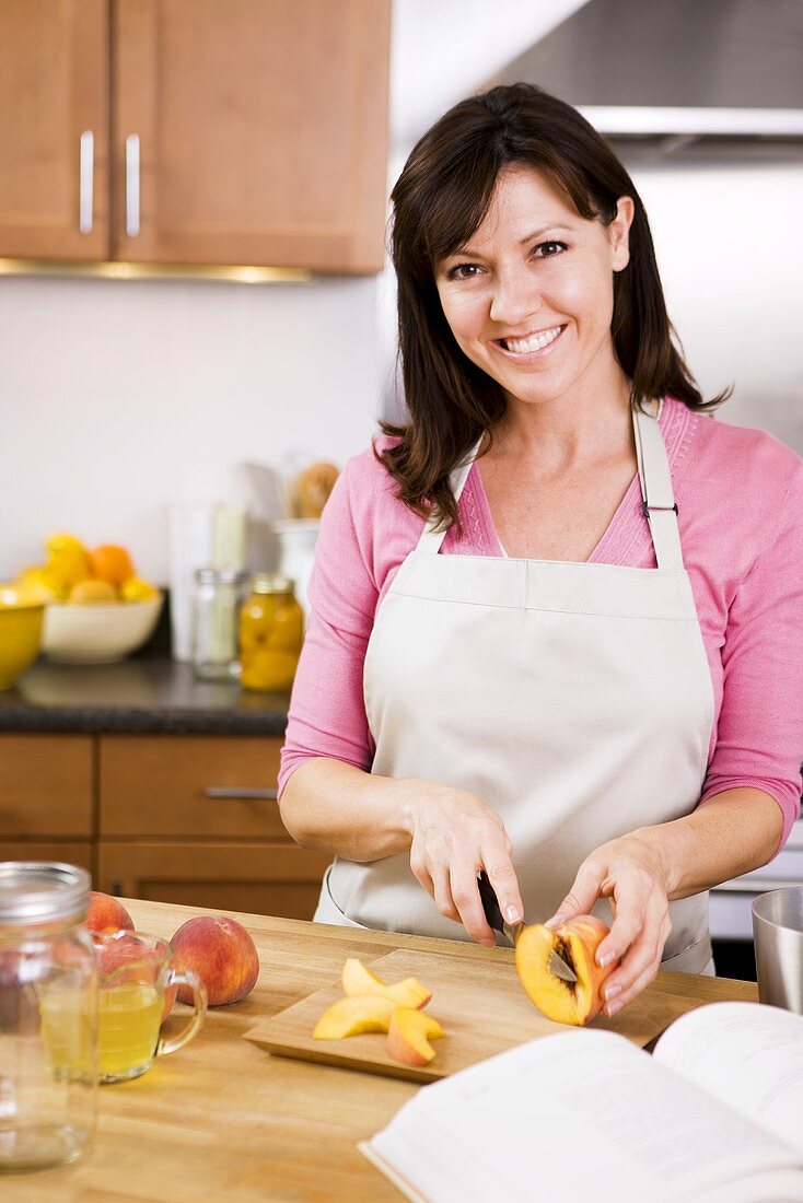 Woman Preparing Peaches for Homemade Canned Peaches; In Kitchen
