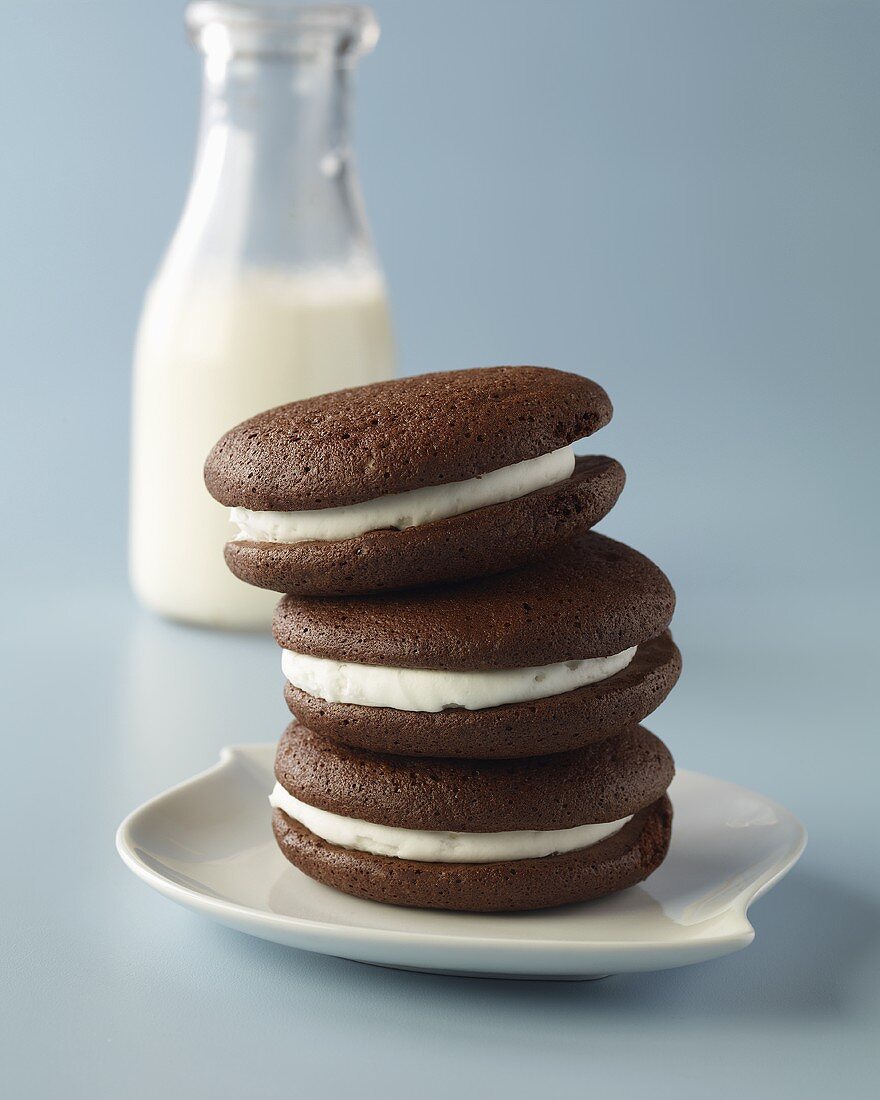 Three Classic Whoopie Pies Stacked on a Plate; Bottle of Milk