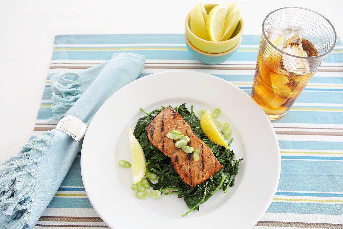 Gegrillter Lachs mit Spinat und Zitronenschnitze; dazu Eistee