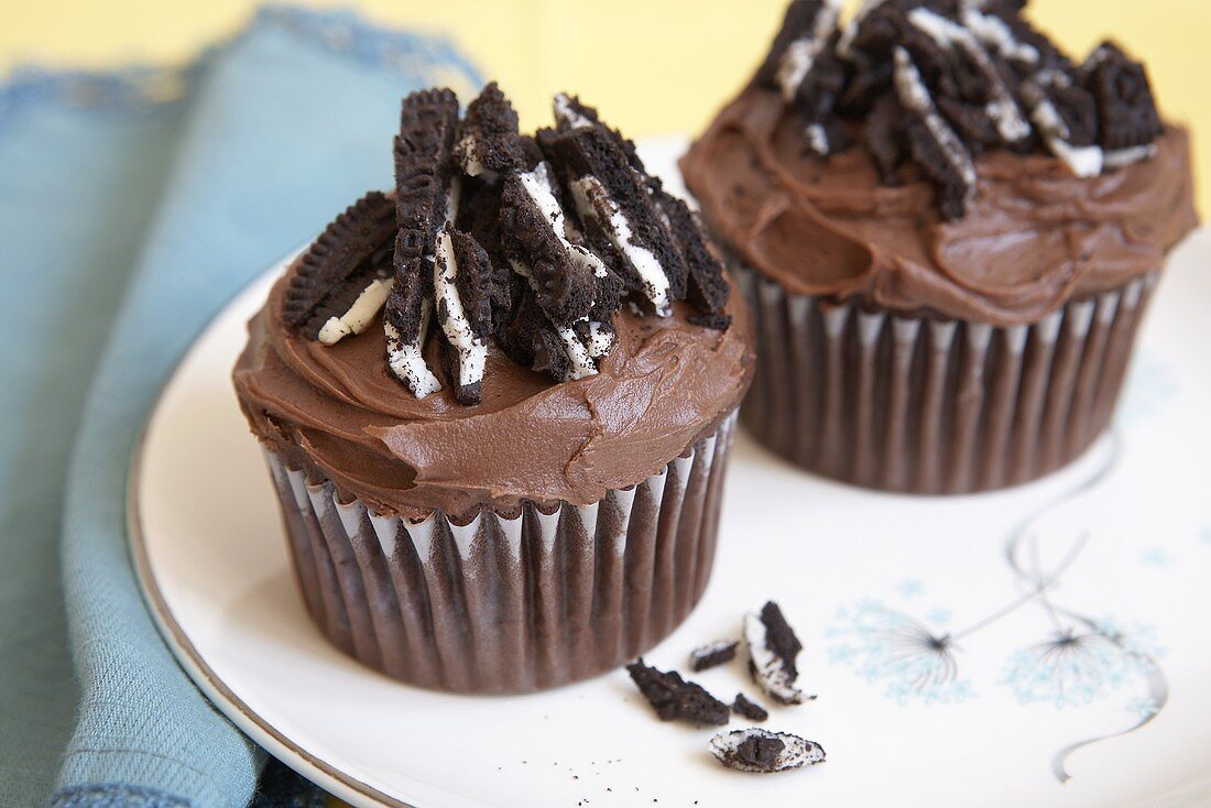 Two Chocolate Frosted Cupcakes Topped with Oreo Cookies
