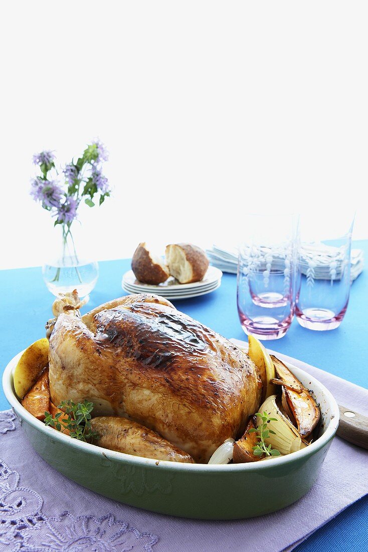 Whole Roast Chicken in Baking Dish with Vegetables; On Table