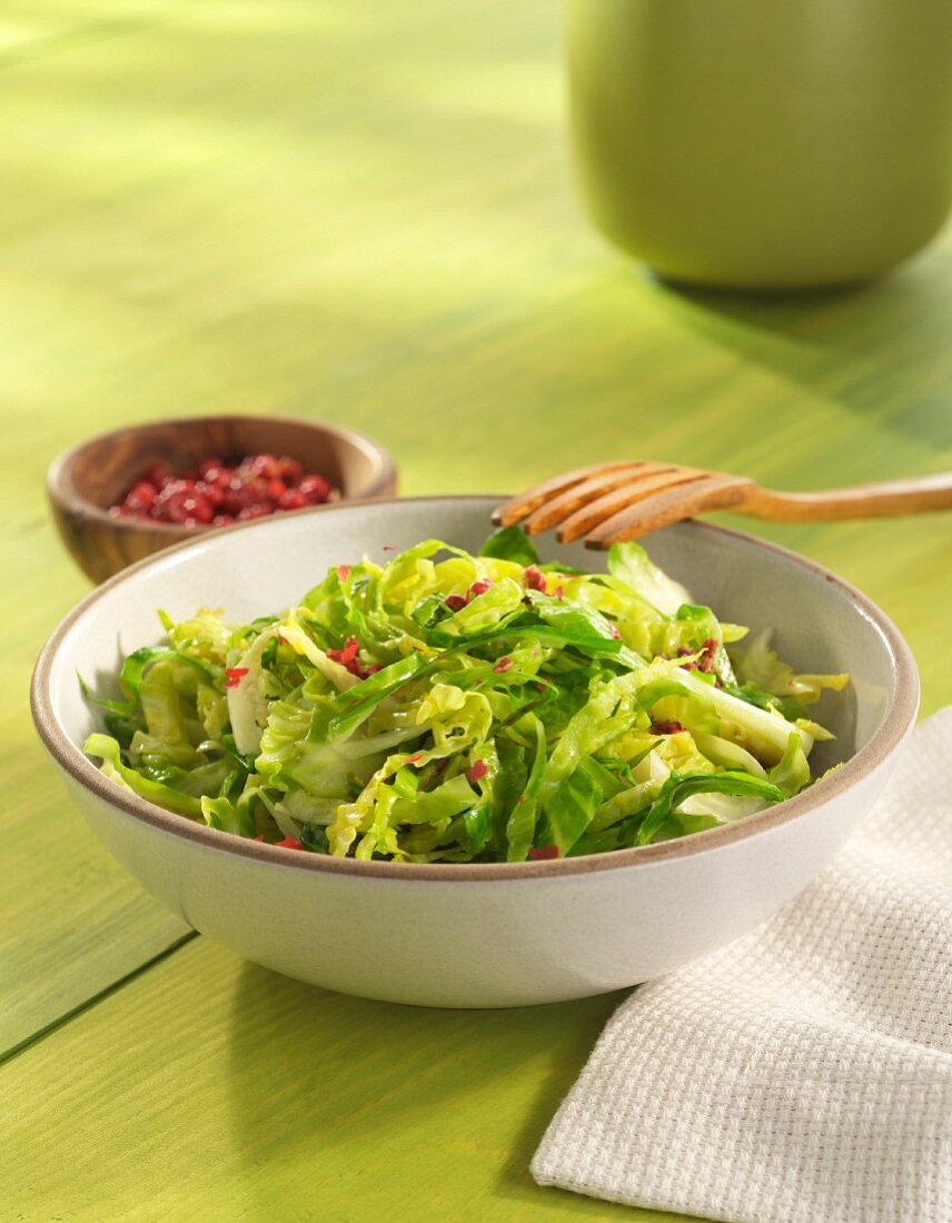 Shredded Brussels Sprouts in a white Bowl with Bacon Bits