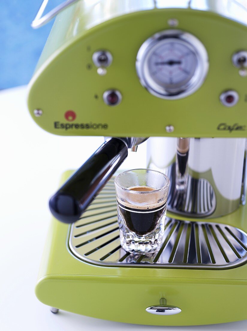 Grüne Espressomaschine mit einem Glas Espresso