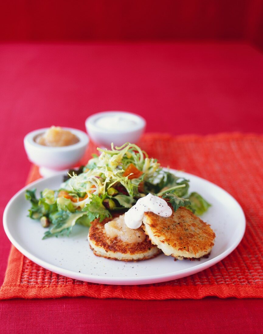 Potato cakes with apple sauce, sour cream and a side salad