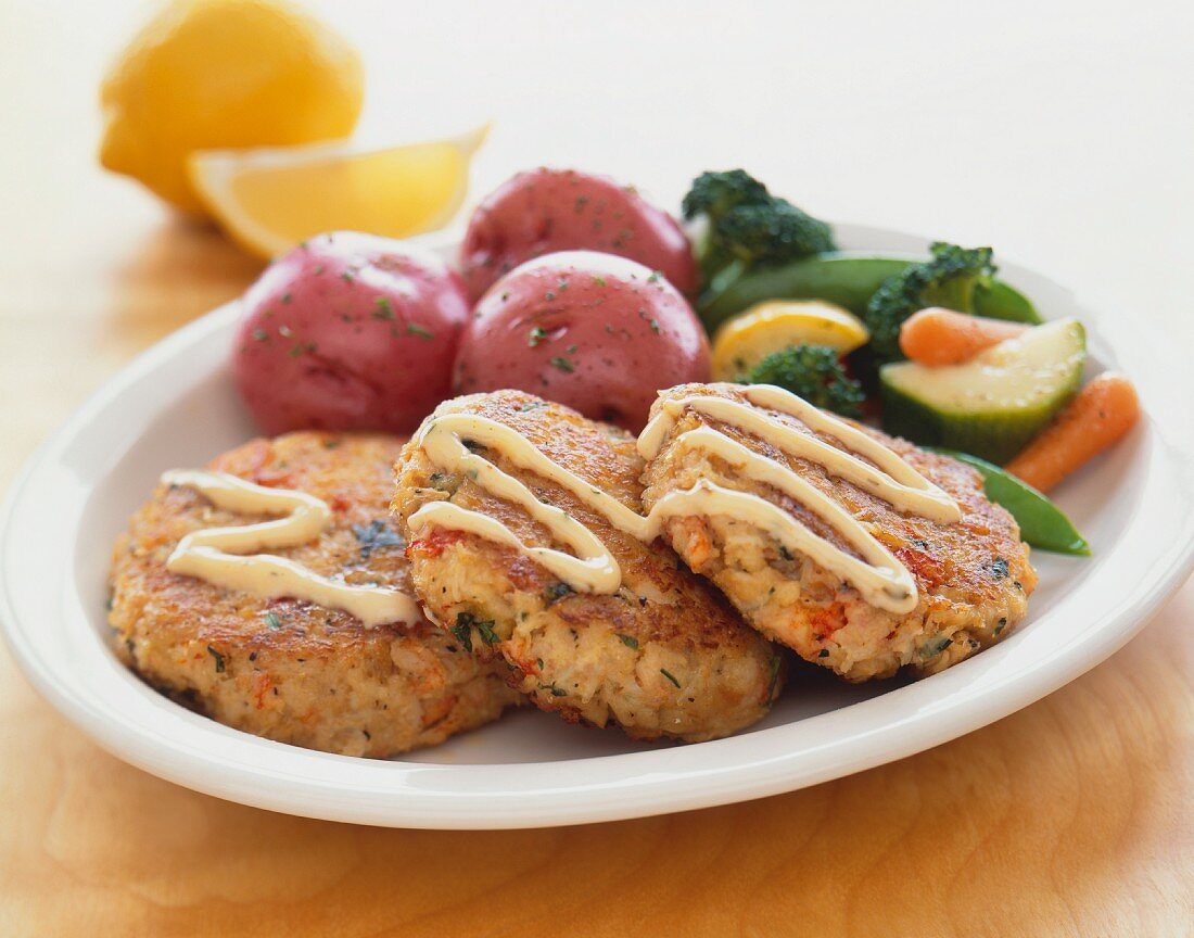Crab Cakes with Red Potatoes and Vegetables on a White Plate
