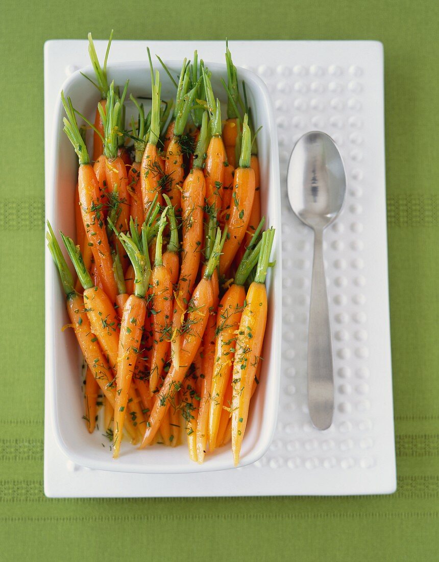 Baby Carrots with Stems and Herbs in a Serving Bowl; From Above