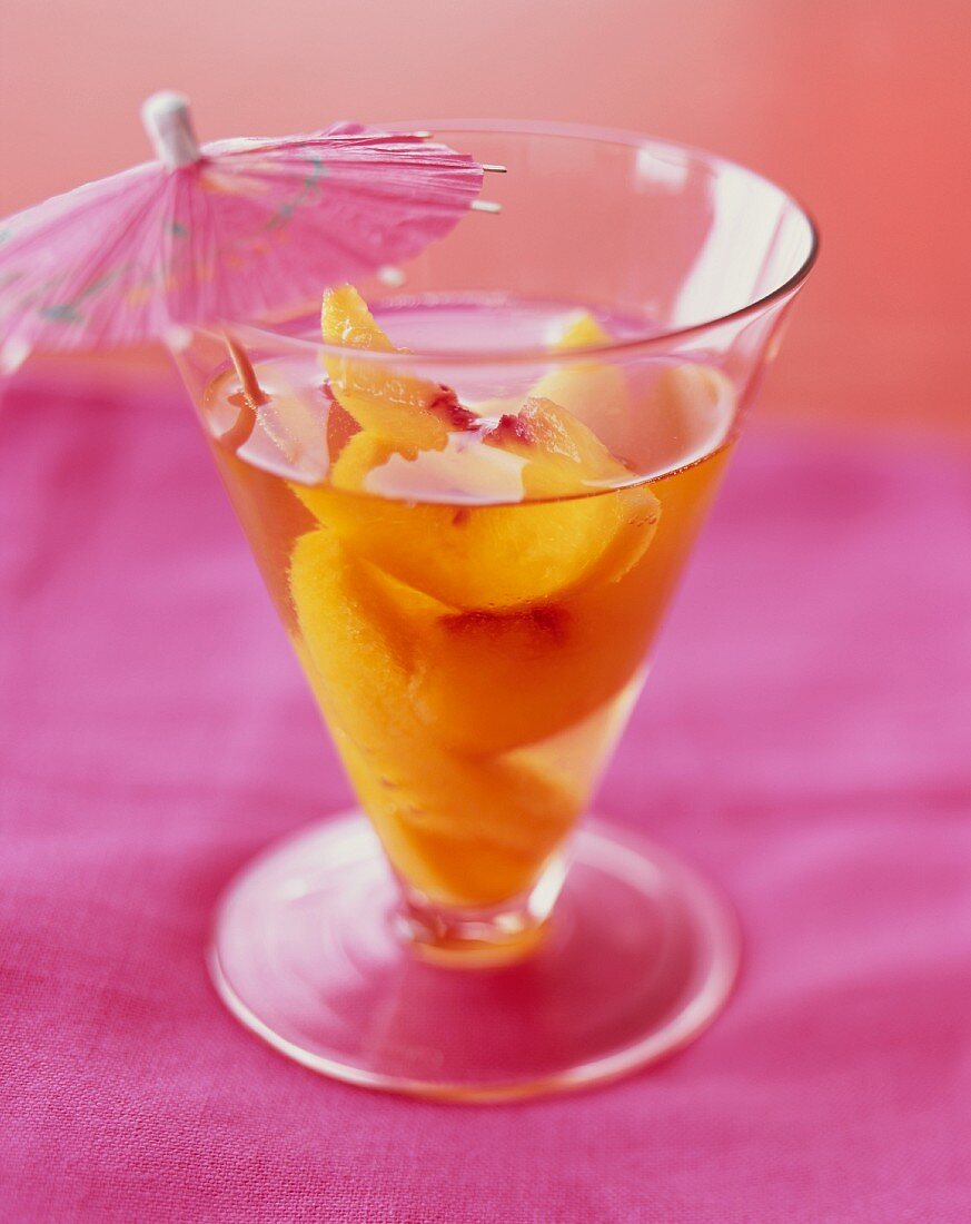 Pfirsich-Cocktail im Glas mit Cocktailschirmchen