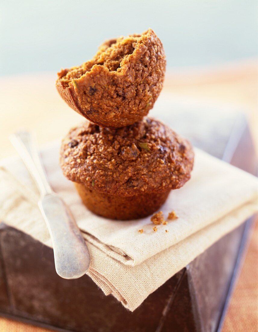 Half a Bran Muffin On Top of a Whole Bran Muffin; Knife