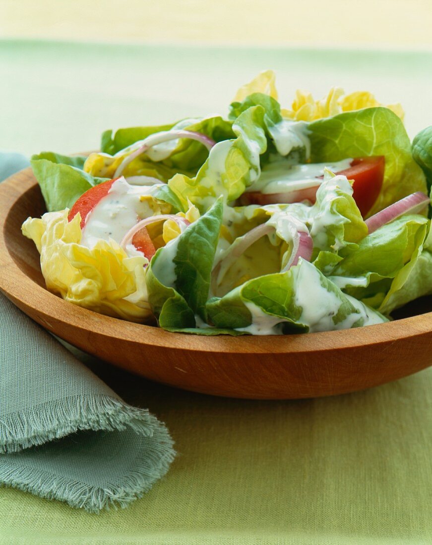 Green Salad in a Wooden Bowl with Creamy Dressing