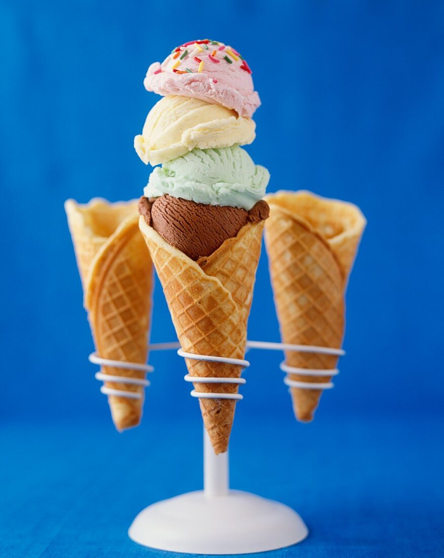 Three Ice Cream Cones on a Stand; Two Empty and One with Four Assorted Scoops of Ice Cream