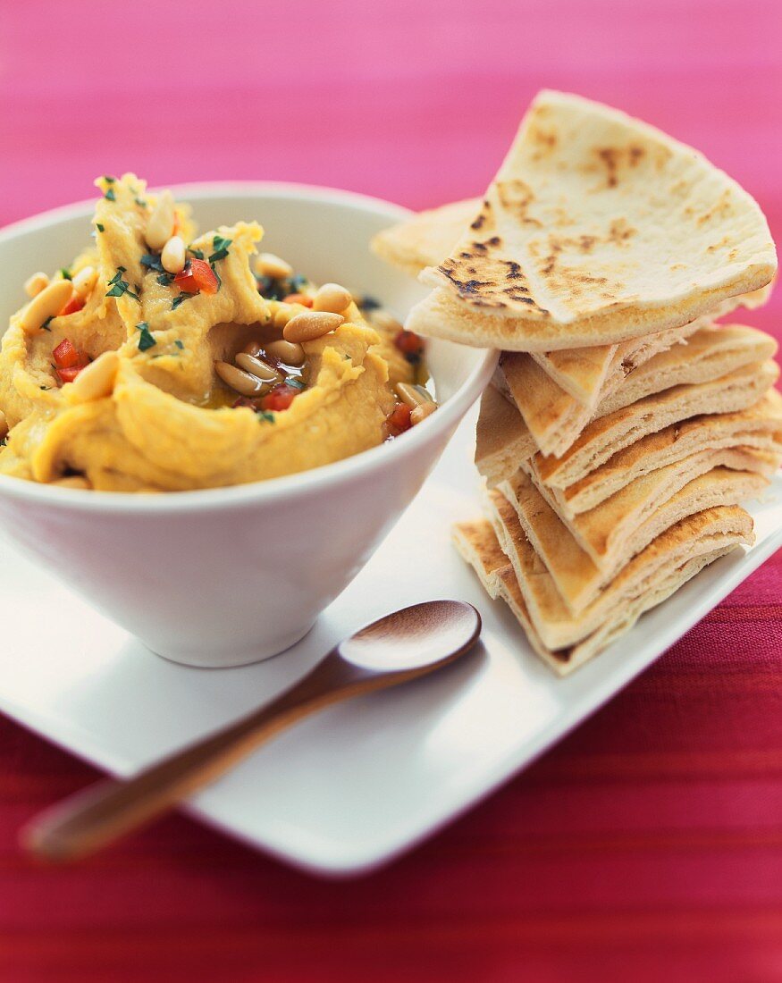 Bowl of Hummus with a Stack of Pita Triangles for Dipping