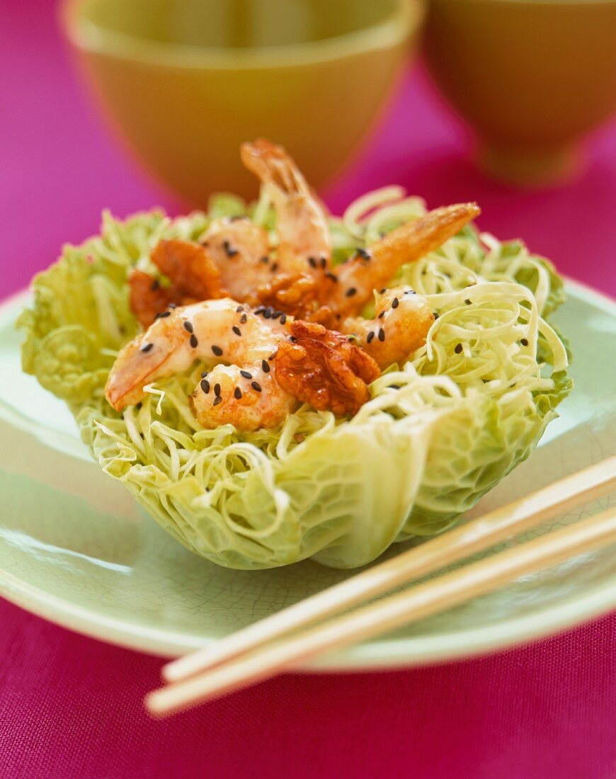 Honey Walnut Shrimp Served in a Cabbage Bowl Garnished with Black Sesame Seeds; Chopsticks