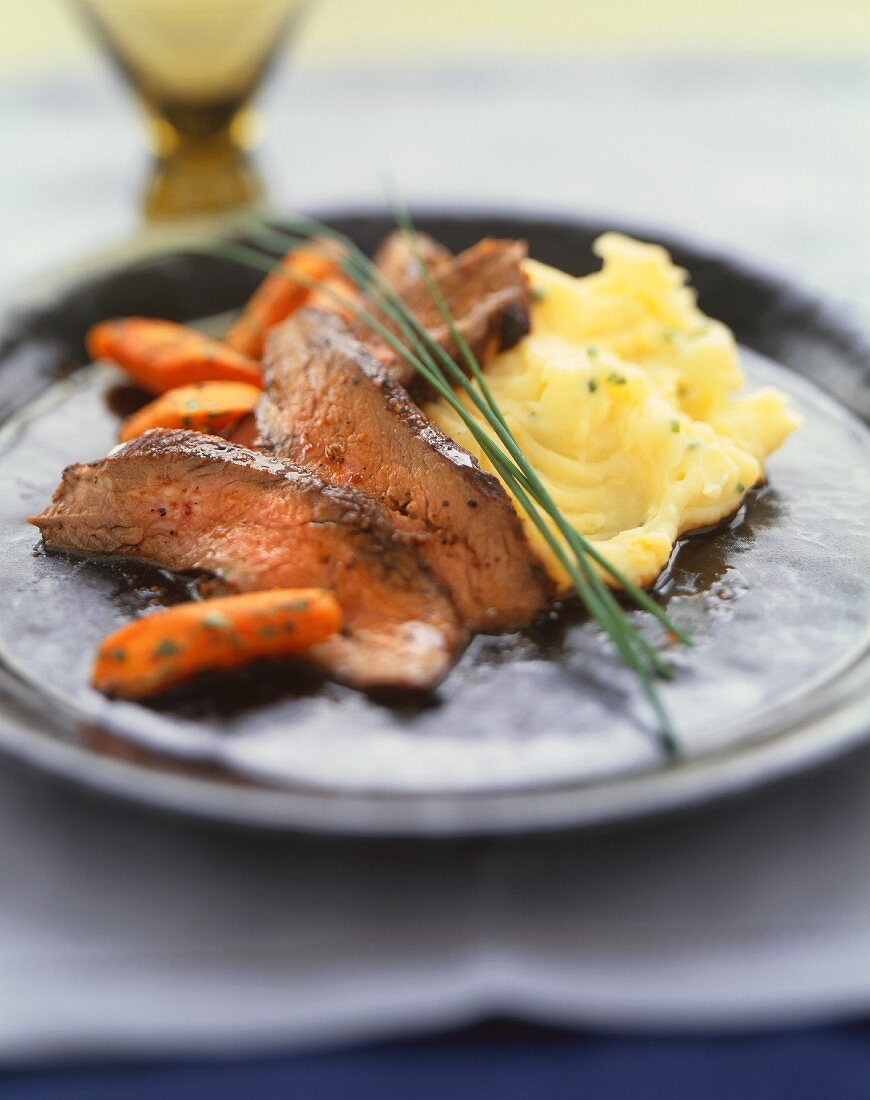 Sliced Flank Steak with Mashed Potatoes and Carrots; Chive Garnish