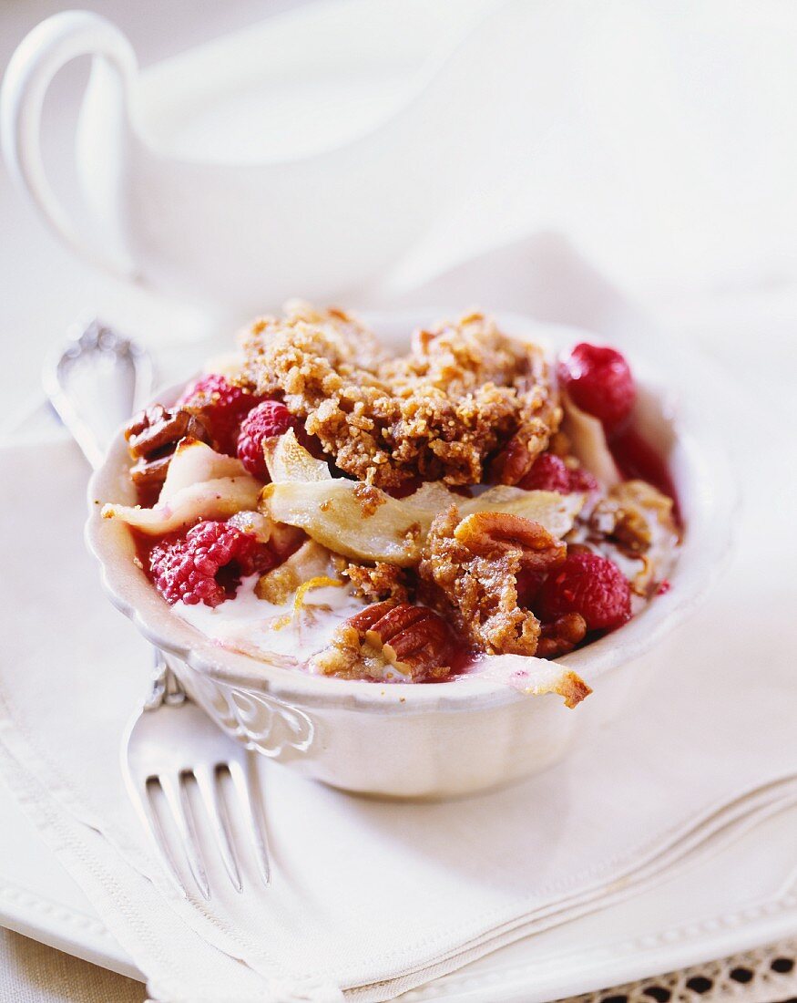Raspberry and pear crisp with pecan nuts and coconut sauce