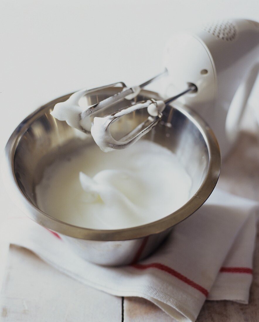 Schüssel mit Eischnee und Handrührgerät